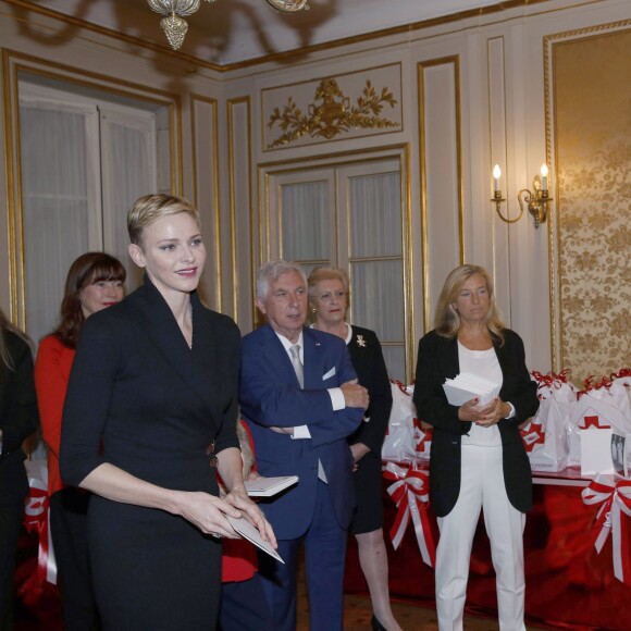 La princesse Charlene a distribué avec le prince Albert II de Monaco, le 17 novembre 2015, à l'avant-veille de la Fête nationale, des colis de la Croix-Rouge monegasque aux personnes âgées à Monaco le 17 novembre 2015. En prime cette année, une photo du couple princier posant avec ses enfants le prince héréditaire Jacques et la princesse Gabriella. © Jean-Charles Vinaj / Pool restreint / Bestimage