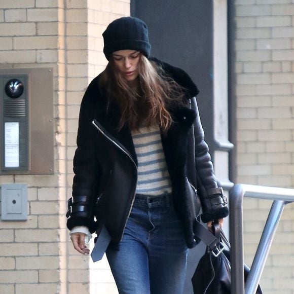 Keira Knightley quitte son appartement à New York, dans son shearling Acne Studios et chaussée de bottines Dr Martens. L'actrice tient à la main un sac Givenchy. Le 19 décembre 2015.