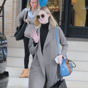 Elle Fanning à la sortie du centre commercial Barneys New York à Beverly Hills, porte un sac Miu Miu et des mocassins Chanel. Le 22 décembre 2015.