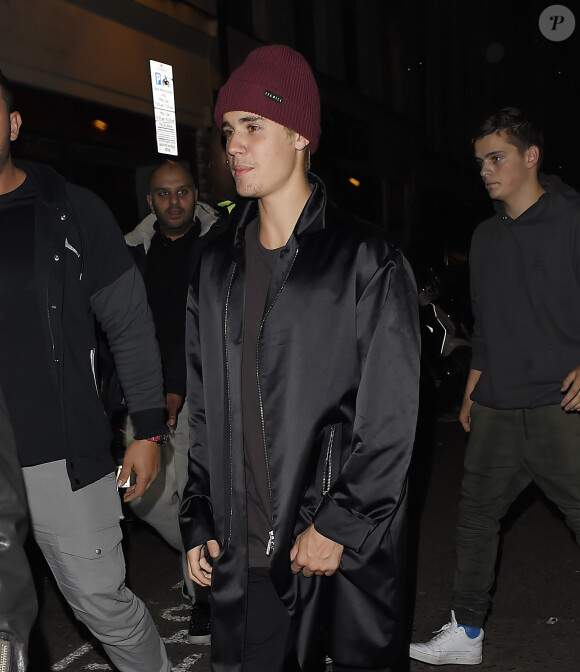 Justin Bieber, escorté par ses gardes du corps, traverse une foule de fans pour se rendre au bar "The Crow" avant d'aller faire la fête à la boîte de nuit "Tape" après la cérémonie des Brit Awards à Londres le 24 février 2016
