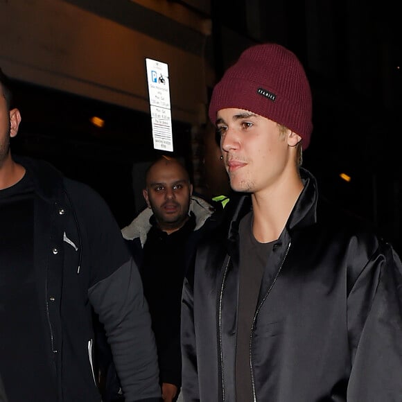 Justin Bieber, escorté par ses gardes du corps, traverse une foule de fans pour se rendre au bar "The Crow" avant d'aller faire la fête à la boîte de nuit "Tape" après la cérémonie des Brit Awards à Londres le 24 février 2016