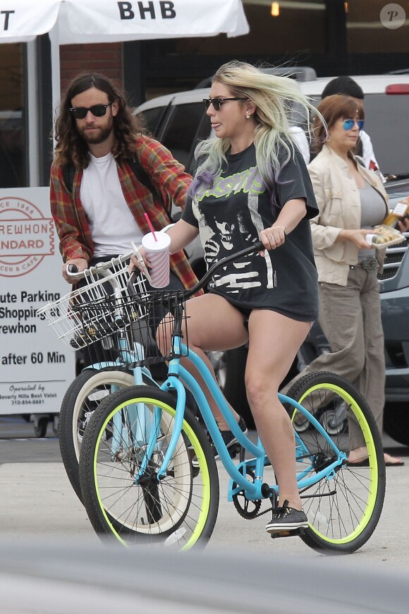 Exclusif - Kesha et son compagnon Brad Ashenfelter se baladent à vélo à Los Angeles, le 7 avril 2016. © CPA/Bestimage