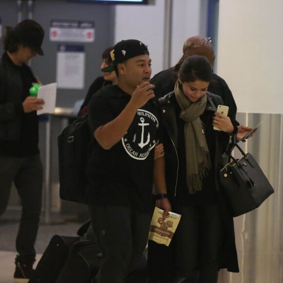 Exclusif - Orlando Bloom et Selena Gomez (sac Prada modèle Saffiano) quittent l'aéroport de LAX à Los Angeles, le 20 octobre 2014