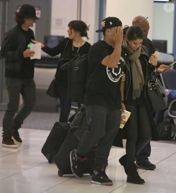Exclusif - Orlando Bloom et Selena Gomez (sac Prada modèle Saffiano) quittent l'aéroport de LAX à Los Angeles, le 20 octobre 2014