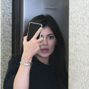 Kylie Jenner et son compagnon Tyga à la sortie d'un centre médical à Beverly Hills. Kylie cache son visage avec son téléphone pendant que Tyga fait un doigt d’honneur aux photographes! le 1er juillet 2016