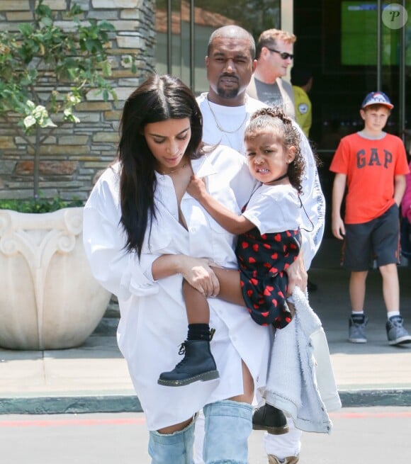 Kim Kardashian avec son mari Kanye West et leur fille North West sortent du cinema après avoir vu le film "Finding Dory" à Calabasas le 25 juin 2016.