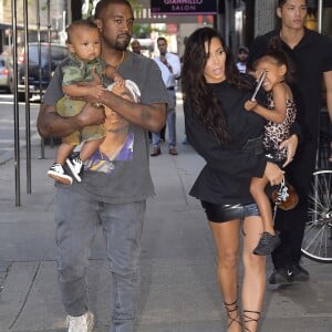 Kim Kardashian et son mari Kanye West dans les rues de New York avec leurs enfants North et Saint dans les bras, le 29 août 2016