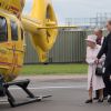 Le pricne William à l'aéroport de Cambridge le 13 juillet 2016, faisant visiter les lieux et découvrir son hélicoptère à la reine Elizabeth II et au duc d'Edimbourg, qui inauguraient les nouveaux locaux d'East Anglia Air Ambulance.