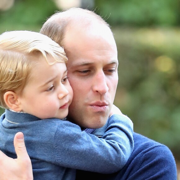 Le prince George de Cambridge dans les bras de son père le prince William le 29 septembre 2016 lors d'une fête avec des familles de militaires à la Maison du Gouvernement de Victoria, en Colombie-Britannique, au cours de leur tournée royale au Canada.