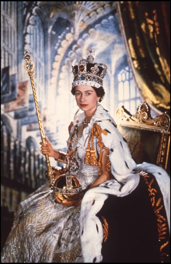 La reine Elisabeth II le jour de son couronnement, avec les attributs du monarque (le sceptre, l'orbe et la couronne de St Edward), le 2 juin 1953 en l'abbaye de Westminster. The Crown, série originale Netflix, revisite ce moment historique dans sa première saison, maintenant disponible.