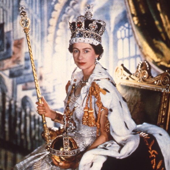 La reine Elisabeth II le jour de son couronnement, avec les attributs du monarque (le sceptre, l'orbe et la couronne de St Edward), le 2 juin 1953 en l'abbaye de Westminster. The Crown, série originale Netflix, revisite ce moment historique dans sa première saison, maintenant disponible.