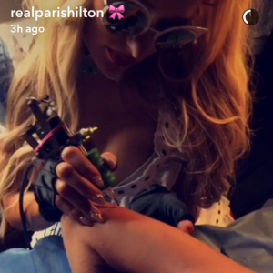 Paris Hilton s'improvise tatoueuse et tatoue son autographe sur le bras de sa copine Jasmine Walz lors de la soirée d'Halloween du magazine Treats, le 29 octobre 2016. Photo extraite d'une vidéo publiée sur le compte Snapchat de l'héritière.
