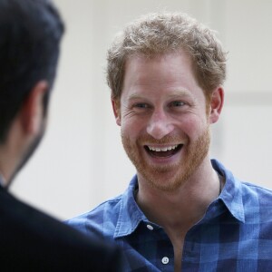 Le prince Harry, portant le ruban rouge de la lutte contre le sida, assiste aux répétitions du choeur Joyful Noise des membres de l'association caritative NAZ au club Hurlingham à Londres, le 15 novembre 2016.