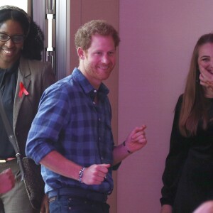 Le prince Harry, portant le ruban rouge de la lutte contre le sida, assiste aux répétitions du choeur Joyful Noise des membres de l'association caritative NAZ au club Hurlingham à Londres, le 15 novembre 2016.