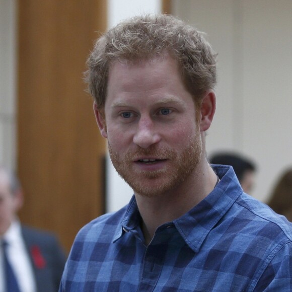 Le prince Harry, portant le ruban rouge de la lutte contre le sida, assiste aux répétitions du choeur Joyful Noise des membres de l'association caritative NAZ au club Hurlingham à Londres, le 15 novembre 2016.