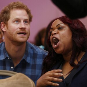 Le prince Harry, portant le ruban rouge de la lutte contre le sida, assiste aux répétitions du choeur Joyful Noise des membres de l'association caritative NAZ au club Hurlingham à Londres, le 15 novembre 2016.