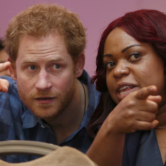 Le prince Harry, portant le ruban rouge de la lutte contre le sida, assiste aux répétitions du choeur Joyful Noise des membres de l'association caritative NAZ au club Hurlingham à Londres, le 15 novembre 2016.