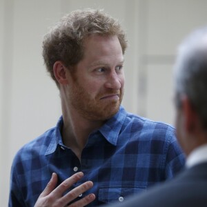 Le prince Harry, portant le ruban rouge de la lutte contre le sida, assiste aux répétitions du choeur Joyful Noise des membres de l'association caritative NAZ au club Hurlingham à Londres, le 15 novembre 2016.