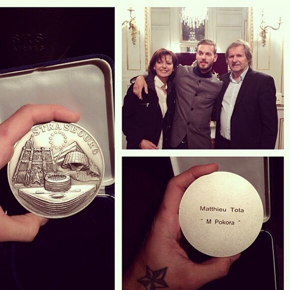 Le chanteur M. Pokora pose avec ses parents après avoir reçu des mains du maire de Strasbourg Roland Ries la médaille d'honneur de la ville, lors d'une cérémonie organisée en présence de fans à l'hôtel de ville de Strasbourg, le 12 février 2014.