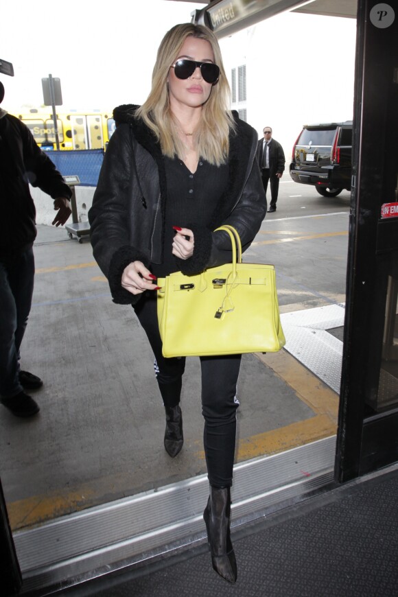 Khloe Kardashian arrive à l'aéroport LAX de Los Angeles avec un sac Hermès jaune canari le 7 décembre 2016