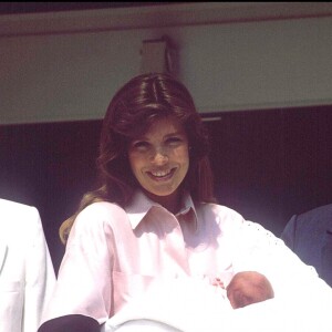 La princesse Caroline de Monaco, portant sa fille Charlotte Casiraghi, entourée de son frère le prince Albert et leur père le prince Rainier à la sortie de la maternité en août 1986.