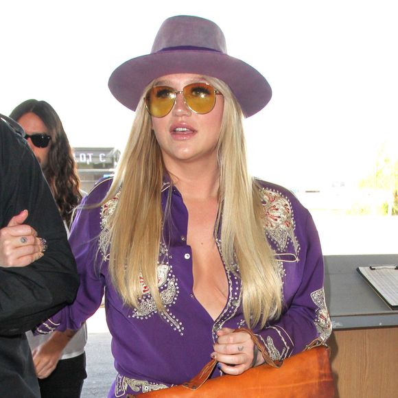 La chanteuse Kesha arrive, bras dessus bras dessous avec son garde du corps, à l'aéroport LAX de Los Angeles pour prendre un avion, le jour de la Saint-Valentin. Le 14 février 2017