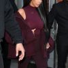 Kim Kardashian habillée de la tête aux pieds en bordeaux avec un haut très transparent à la sortie d'un immeuble à New York, le 15 février 2017