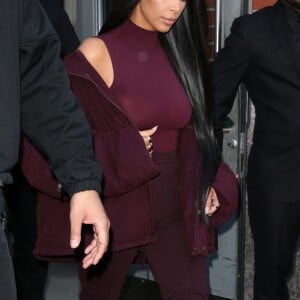 Kim Kardashian habillée de la tête aux pieds en bordeaux avec un haut très transparent à la sortie d'un immeuble à New York, le 15 février 2017