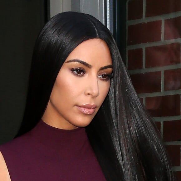 Kim Kardashian habillée de la tête aux pieds en bordeaux avec un haut très transparent à la sortie d'un immeuble à New York, le 15 février 2017