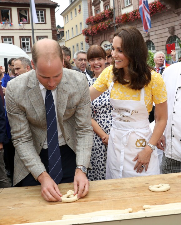 Le prince William et Kate Middleton, duchesse de Cambridge, ont été initiés à la confection de bretzels par le boulanger Andeas Gobes le 20 juillet 2017 sur le marché central d'Heidelberg lors de leur visite officielle en Allemagne.