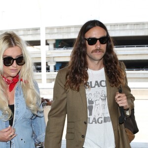 Kesha et son compagnon Brad Ashenfelter arrivent à l'aéroport de LAX à Los Angeles. Kesha fait un doigt d'honneur aux photographes! Le 1er juin 2017