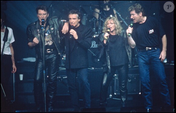 Johnny Hallyday, Michel Sardou, Véronique Sanson et Eddy Mitchell sur scène pour un concert lors de la tournée des Enfoirés, le 9 novembre 1989.