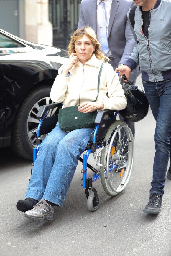 Exclusif - Mathilde Seigner, toujours en fauteuil roulant à la suite d'une fracture de la malléole, quitte la radio RTL à Paris le 5 avril 2017.