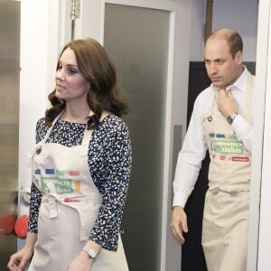 La duchesse Catherine de Cambridge, enceinte, et le prince William ont pris part aux préparatifs du Commonwealth Big Lunch le 22 mars 2018 au centre communautaire St Luke à Londres. Son ultime engagement avant son congé maternité, Kate l'aura accompli... en tablier !