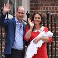  La duchesse Catherine de Cambridge (Kate Middleton), en robe Jenny Packham rappelant la tenue rouge de Lady Diana 34 ans plus tôt dans les mêmes circonstances, avec le prince William et leur troisième enfant à la sortie de l'aile Lindo du St Mary's Hospital le 23 avril 2018. 