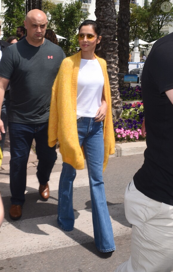 Cheryl Cole, habillée d'un cardigan jaune, d'un t-shirt blanc et d'un jean RE/DONE, se promène sur la Croisette lors du 71ème Festival International du Film de Cannes, le 12 mai 2018.