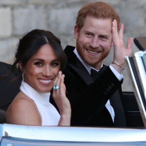 Le prince Harry, duc de Sussex, et Meghan Markle, duchesse de Sussex quittent le château de Windsor à bord d'une Jaguar Type E cabriolet en tenue de soirée après leur cérémonie de mariage, pour se rendre à la réception à Frogmore House à Windsor le 19 mai 2018.