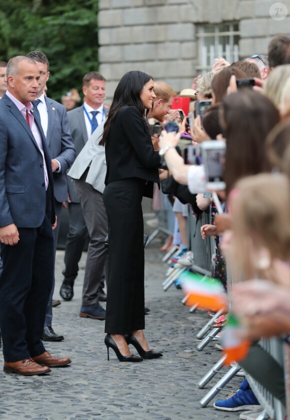 Le prince Harry, duc de Sussex et sa femme Meghan Markle, duchesse de Sussex saluent la foule lors de leur visite au collège de la trinité à Dublin le 11 juillet 2018