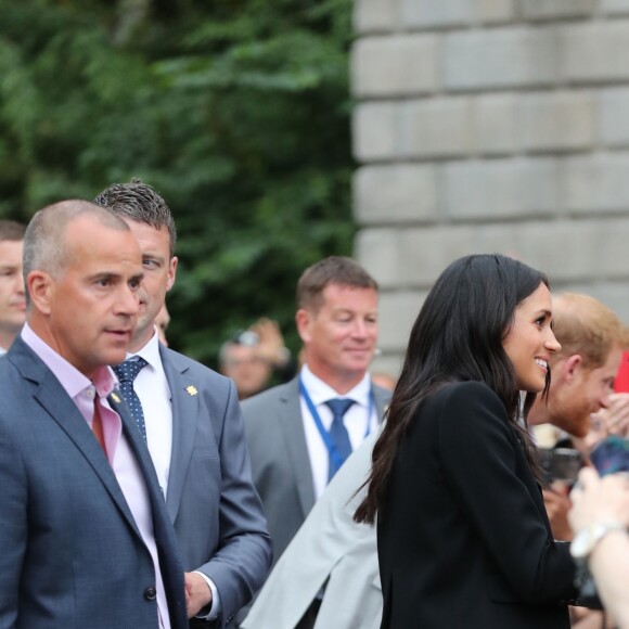 Le prince Harry, duc de Sussex et sa femme Meghan Markle, duchesse de Sussex saluent la foule lors de leur visite au collège de la trinité à Dublin le 11 juillet 2018