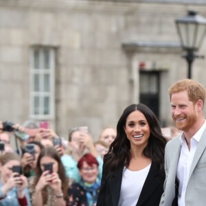 Le prince Harry, duc de Sussex et sa femme Meghan Markle, duchesse de Sussex saluent la foule lors de leur visite au collège de la trinité à Dublin le 11 juillet 2018