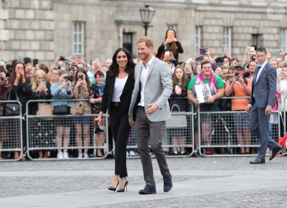 Le prince Harry, duc de Sussex et sa femme Meghan Markle, duchesse de Sussex saluent la foule lors de leur visite au collège de la trinité à Dublin le 11 juillet 2018