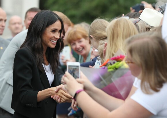 Le prince Harry, duc de Sussex et sa femme Meghan Markle, duchesse de Sussex saluent la foule lors de leur visite au collège de la trinité à Dublin le 11 juillet 2018