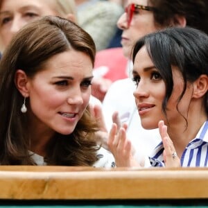 Catherine (Kate) Middleton, duchesse de Cambridge et Meghan Markle, duchesse de Sussex assistent au match de tennis Nadal contre Djokovic lors du tournoi de Wimbledon "The Championships" le 14 juillet 2018.