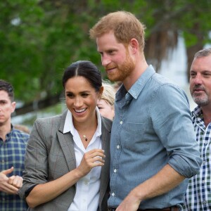 Le prince Harry, duc de Sussex et sa femme Meghan Markle, duchesse de Sussex (enceinte) sont accueillis par des élèves australiens à leur arrivée à Dubbo en Australie dans le cadre de leur première tournée officielle, le 17 octobre 2018.