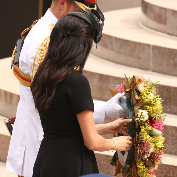 Le prince Harry, duc de Sussex, et Meghan Markle, duchesse de Sussex, enceinte, déposent une couronne au monument de guerre de l'ANZAC à Sydney, le 20 octobre 2018.