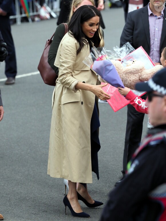 Le prince Harry, duc de Sussex, et Meghan Markle, enceinte, duchesse de Sussex, vont à la rencontre de la foule venue les accueillir, lors de la visite des jardins botaniques de Melbourne, le 18 octobre 2018.
