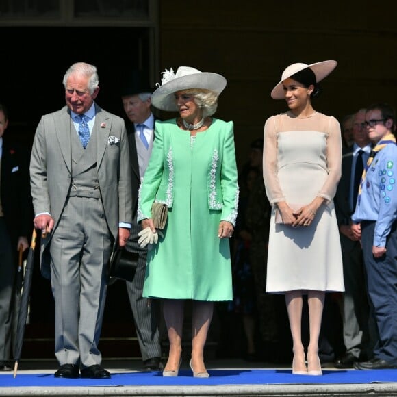 Le prince Charles, la duchesse Camilla, la duchesse Meghan (Meghan Markle) et le prince Harry étaient associés en toute complicité le 22 mai 2018 pour une des fameuses garden parties de Buckingham Palace, à Londres.