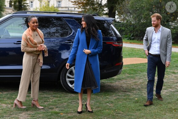 Meghan Markle, duchesse de Sussex, portant une jupe Misha Nonoo et accompagnée par sa mère Doria Ragland et son mari le prince Harry, lors de la réception au palais de Kensington le 20 septembre 2018 des femmes d'une cuisine communautaire qu'elle avait rencontrées auparavant.