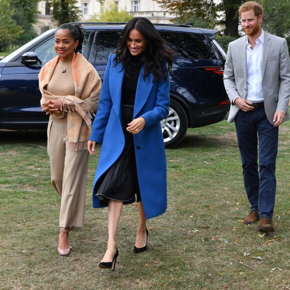 Meghan Markle, duchesse de Sussex, portant une jupe Misha Nonoo et accompagnée par sa mère Doria Ragland et son mari le prince Harry, lors de la réception au palais de Kensington le 20 septembre 2018 des femmes d'une cuisine communautaire qu'elle avait rencontrées auparavant.