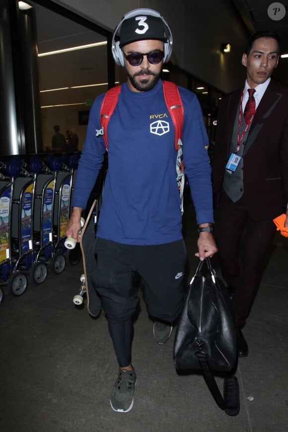 Exclusif - Zac Efron porte un skateboard à la main à son arrivée à l'aéroport de LAX à Los Angeles, le 26 septembre 2018.